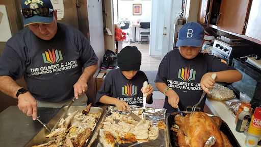 Rep. Gil Cisneros with kids volunteering at last year's Thanksgiving