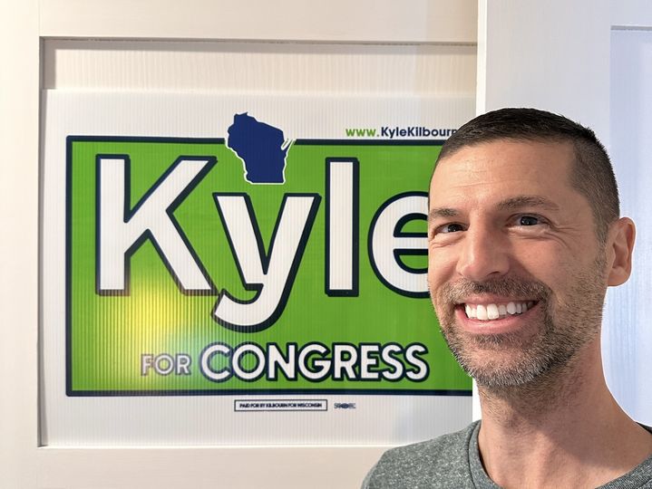 Kyle in front of yard sign