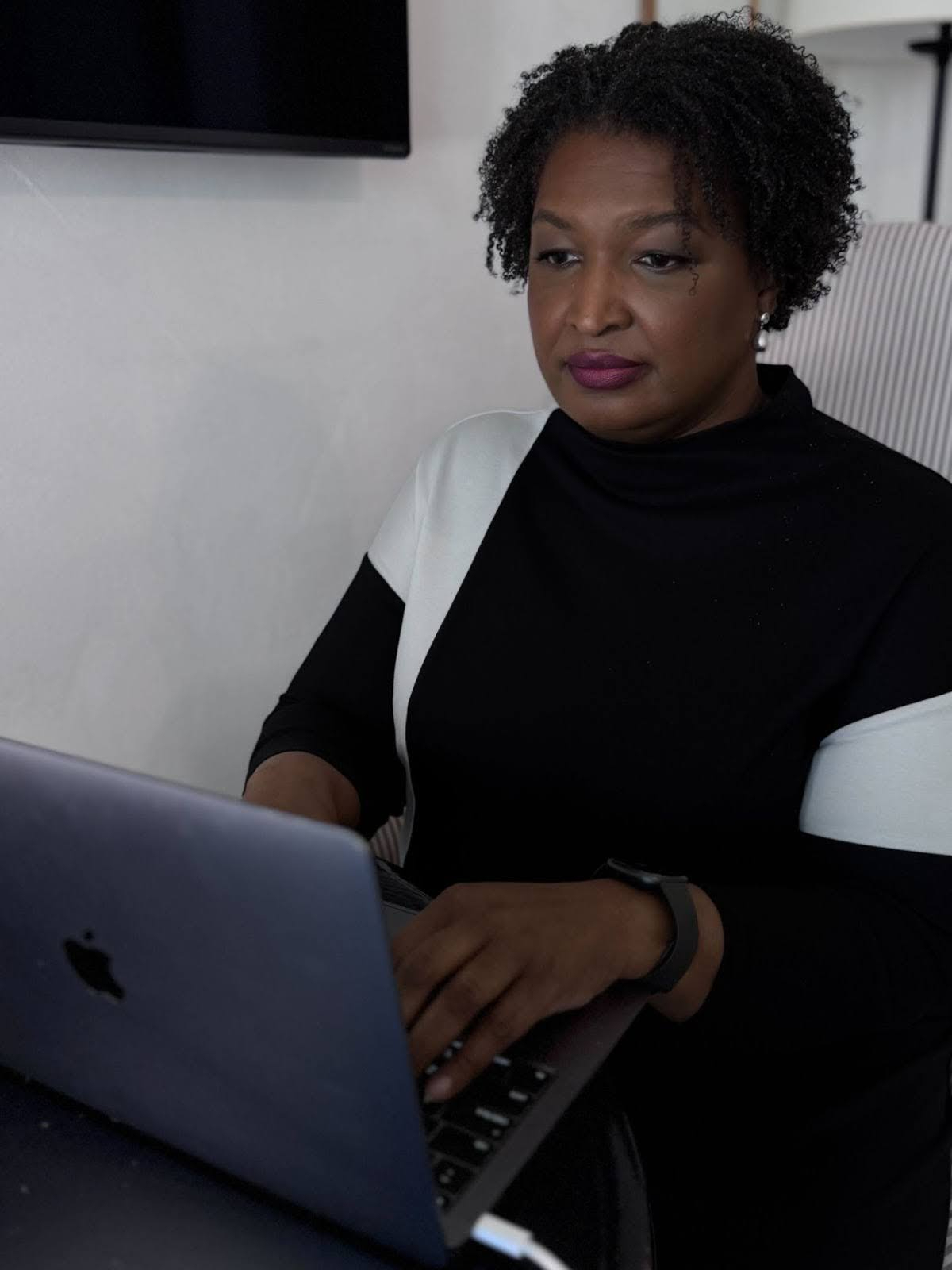 Stacey Abrams typing at a laptop
