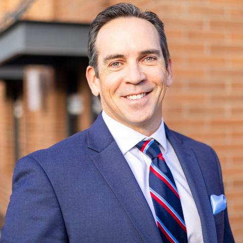 Tyler Kamp headshot, man in suit and tie